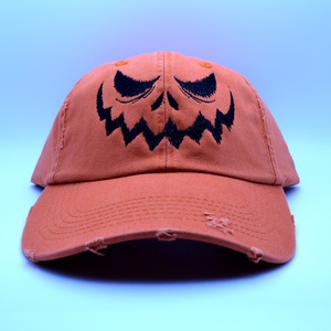 Two hats, one orange and one black, with a jack o lantern face embroidered on the front.