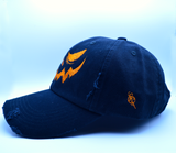 The side of a black baseball style hat with a pumpkin jack o lantern face embroidered on the front in orange thread.