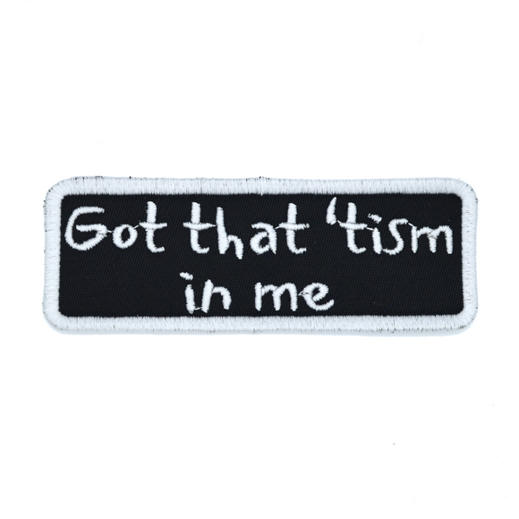 Rectangular black patch with a white border and the words, got that tism in me, embroidered in white thread.