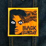Rectangular orange and black embroidered patch for the classic horror movie black sunday. Shown on a denim jacket.
