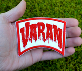 Red and white embroidered logo patch for the classic Kaiju giant monster movie, Varan, the Unbelievable. Shown in the palm of a hand for size reference.