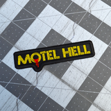 Rectangular black and yellow embroidered logo patch for the classic comedy horror slasher movie Motel Hell.