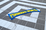 Close up detail of an embroidered logo patch for the classic horror sci-fi movie 'Forbidden World' with blue border and yellow text.