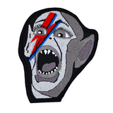 An embroidered patch of the Bat Boy from the classic Weekly World News tabloid with a David Bowie red and blue lightening bolt painted on his face.