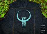 Large embroidered patch made from the logo of the classic first person shooter video game Quake 2. Shown on the back of a denim vest.