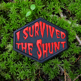 Red on black embroidered patch that says I survived the shunt, in reference to the horror movie, Society.