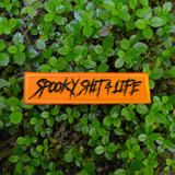 Rectangular orange embroidered patch with the text, spooky shit 4 life, stitched in black thread.