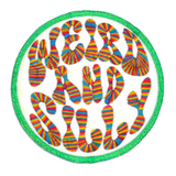 Circular embroidered patch with a bright green border, white background, and the words weird and silly in groovy rainbow lettering.