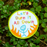 Circular patch with text 'Let's Burn it All Down' with a happy stick figure and flames on a white background and green border.