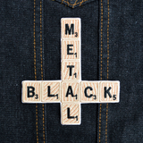 An embroidered patch that says black metal spelled out in Scrabble letters in the shape of an inverted cross.