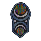 An oblong embroidered patch with abstract geometric arcs and circles in grey, black, and multi-color thread.