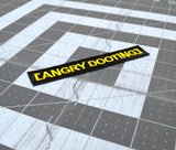 Close up detail of a rectangular black embroidered patch with yellow lettering that says angry dooting, resembling a movie subtitle.