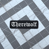 Black rectangular embroidered patch with the word 'therewolf' stitched with white thread in Old English lettering.