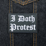 A rectangular black embroidered patch with white Gothic lettering that reads 'I Doth Protest'.