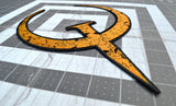 Close up detail of a large rust colored embroidered patch of the logo for the Quake 1 video game.