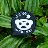 A black embroidered patch in the shape of a chat bubble with an evil-looking version of the reddit logo and the words, 'No Mods, No Masters'.