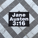 Rectangular black embroidered patch with white block lettering that says, 'Jane Austen 3:16".