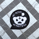 A black embroidered patch in the shape of a chat bubble with an evil-looking version of the reddit logo and the words, 'No Mods, No Masters'.