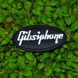An oval-shaped black embroidered patch with the word 'Gibsiphone' stitched in white, resembling the logo for Gibson and Epiphone guitars.