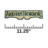 Rectangular embroidered patch resembling a wooden sign with the logo of the Arkham Horror board and card games. Shown with a ruler measurement of 11.25 inches.