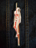 Embroidered patch of a woman impaled on a stake.
