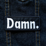 The word 'damn' as an embroidered patch.