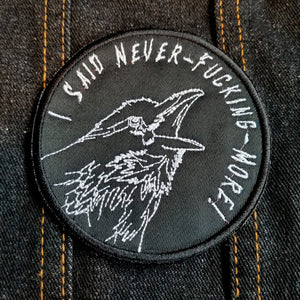 Circular white on black embroidered patch of a raven screaming I said never-fucking-more! 